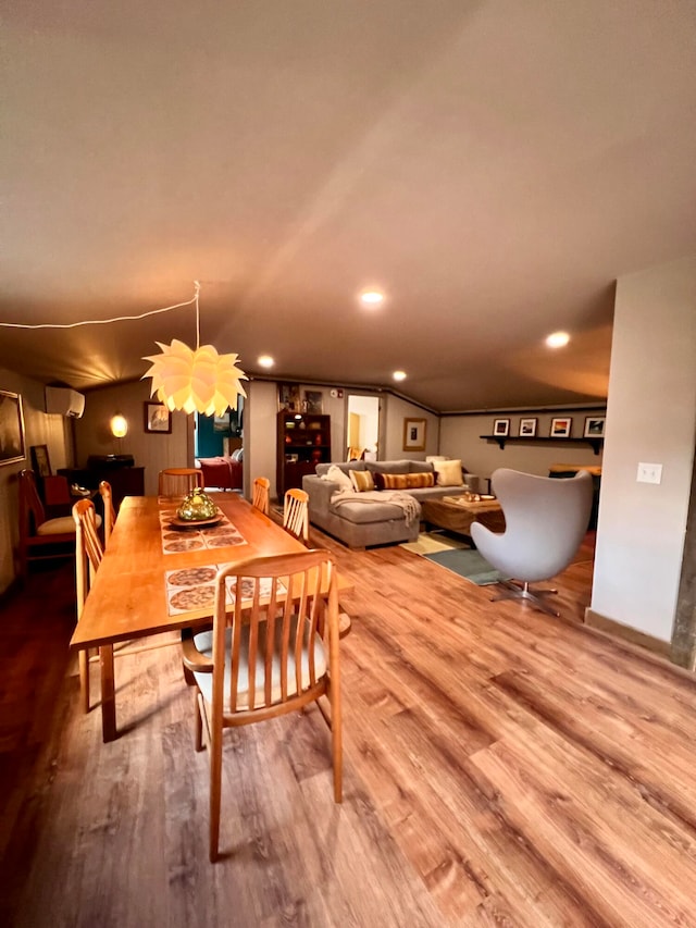 dining room with hardwood / wood-style flooring and a wall mounted AC