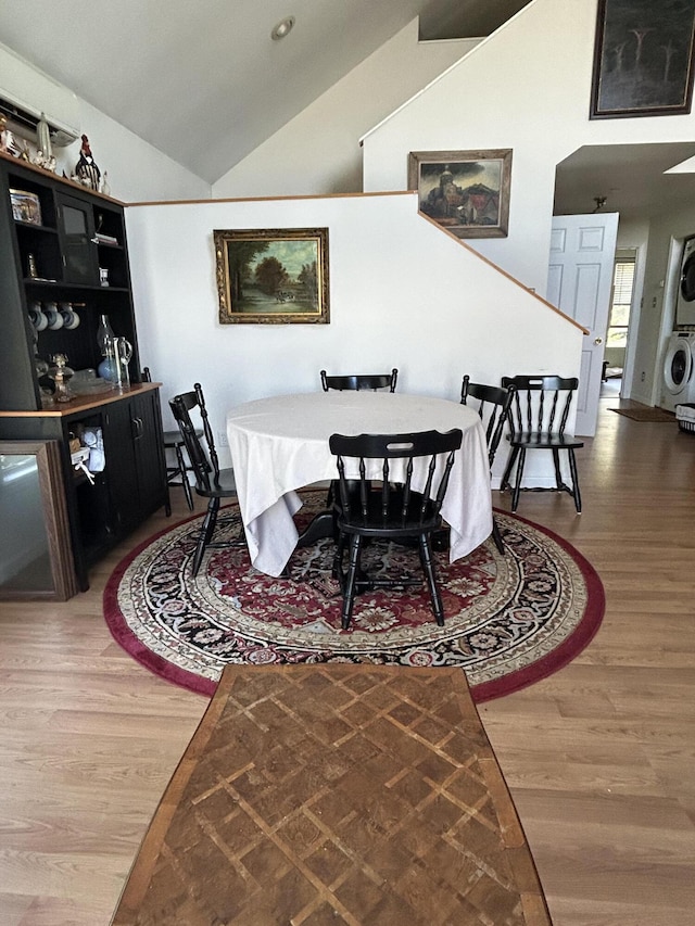 30 Steamboat Rd, Swans Island, ME 04685 - dining room featuring stacked washing maching and dryer, lofted ceiling, and wood finished floors