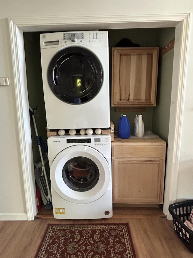 30 Steamboat Rd, Swans Island, ME 04685 - washroom with wood finished floors, cabinet space, and stacked washer / drying machine