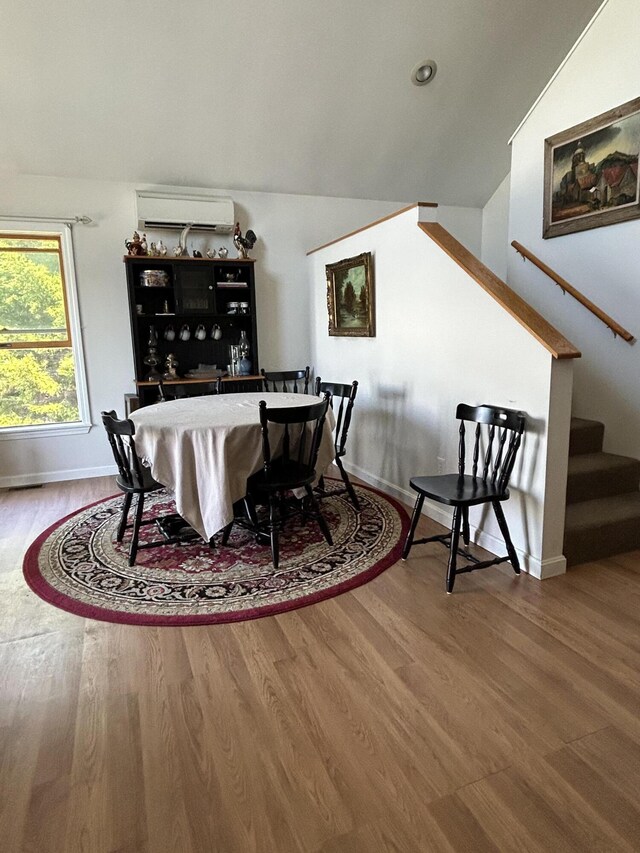 30 Steamboat Rd, Swans Island, ME 04685 - dining area with stairway, wood finished floors, vaulted ceiling, and an AC wall unit