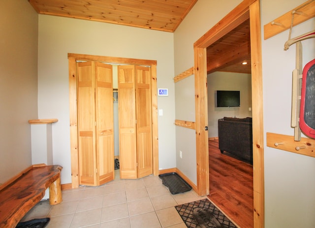 foyer featuring light tile patterned flooring and wood ceiling