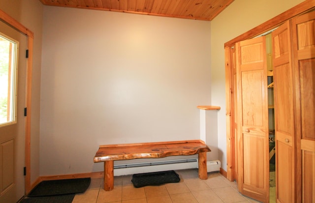 entryway featuring a baseboard heating unit, wood ceiling, baseboards, and light tile patterned floors