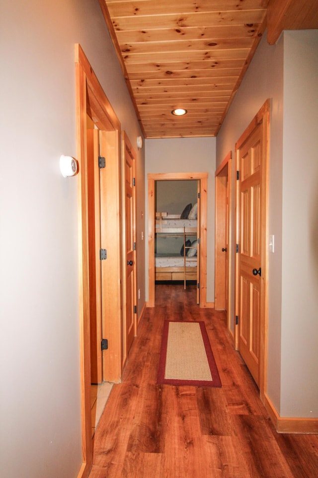 hall with wooden ceiling, baseboards, and wood finished floors