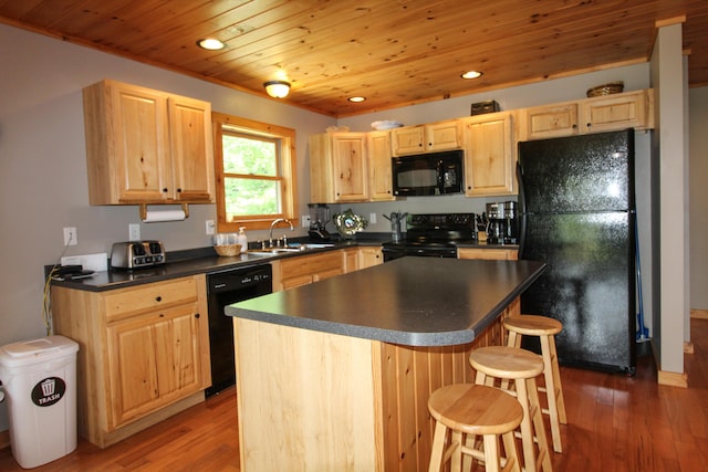 kitchen with light brown cabinets, dark hardwood / wood-style floors, a kitchen island, black appliances, and sink