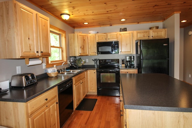 kitchen with black appliances, light brown cabinetry, and dark countertops