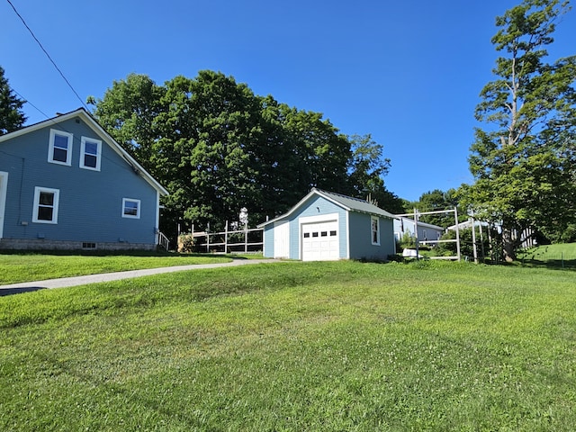 view of yard featuring a detached garage and an outbuilding