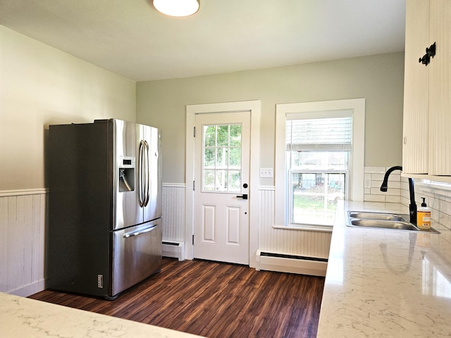 kitchen featuring a sink, baseboard heating, wainscoting, and stainless steel fridge with ice dispenser