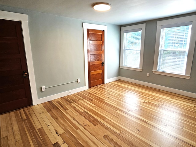 empty room with baseboards and hardwood / wood-style flooring