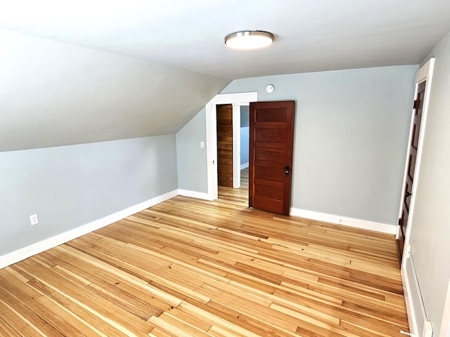 bonus room featuring lofted ceiling, light wood finished floors, and baseboards
