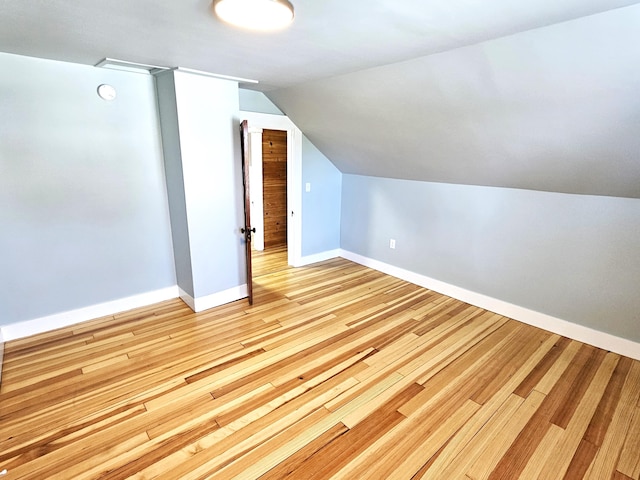 bonus room with lofted ceiling, light wood-type flooring, and baseboards