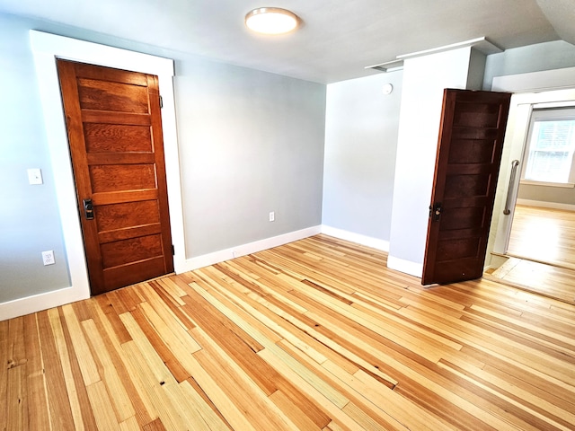 empty room featuring baseboards and light wood-style flooring