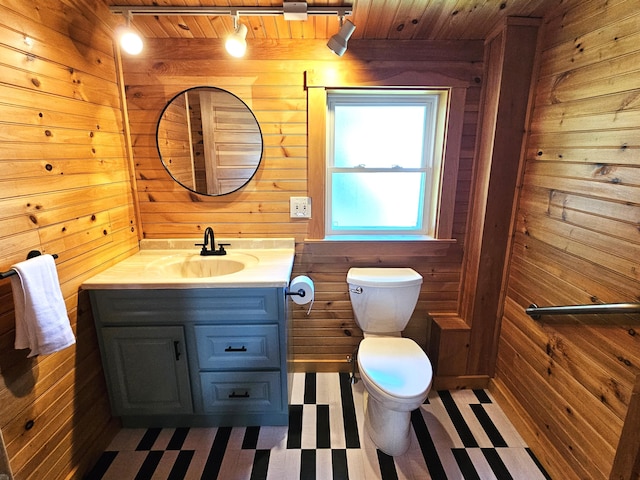 half bath with tile patterned floors, wood walls, and rail lighting