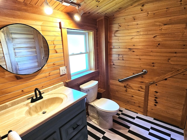 bathroom with wood walls, wooden ceiling, toilet, vaulted ceiling, and vanity