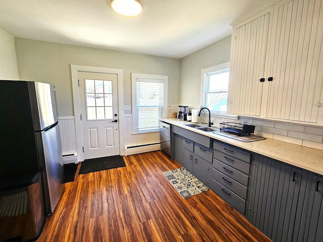 kitchen featuring a baseboard heating unit, a sink, gray cabinets, appliances with stainless steel finishes, and a baseboard radiator