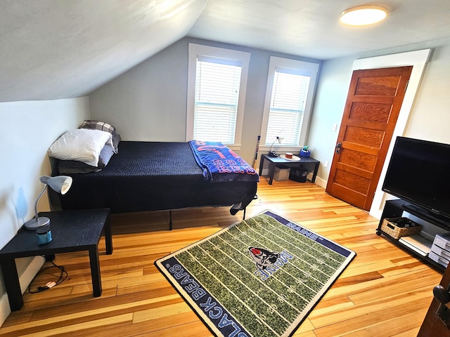 bedroom featuring hardwood / wood-style flooring and vaulted ceiling