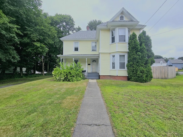 victorian home featuring covered porch and a front yard