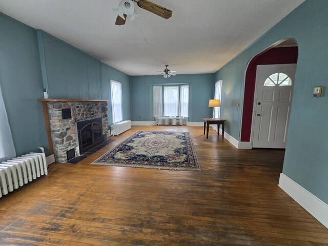 living room with radiator heating unit, a textured ceiling, and dark hardwood / wood-style flooring