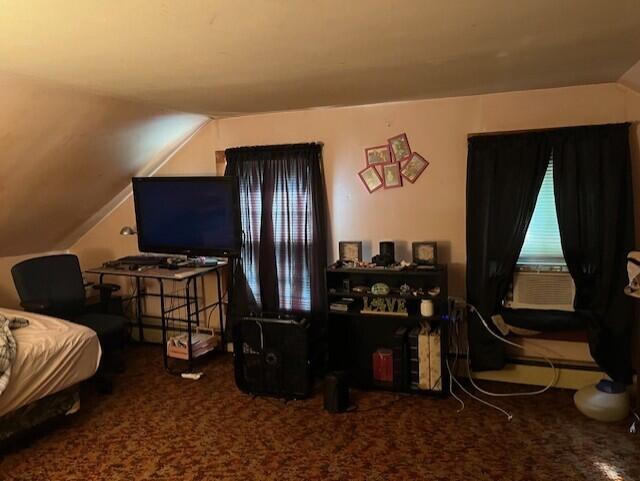 bedroom with carpet floors and vaulted ceiling