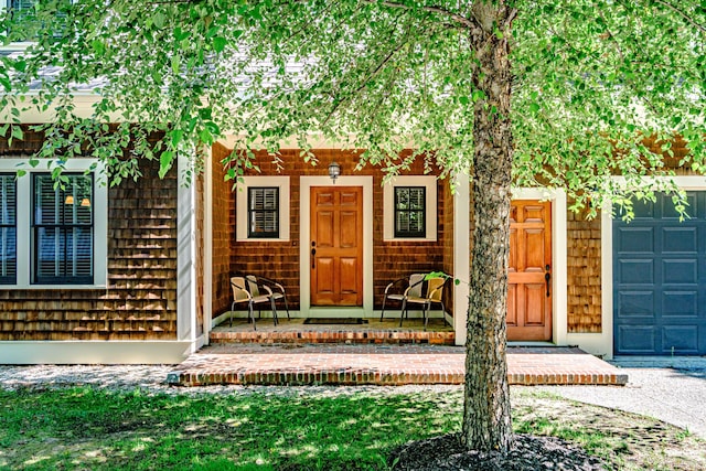 doorway to property featuring a garage and covered porch