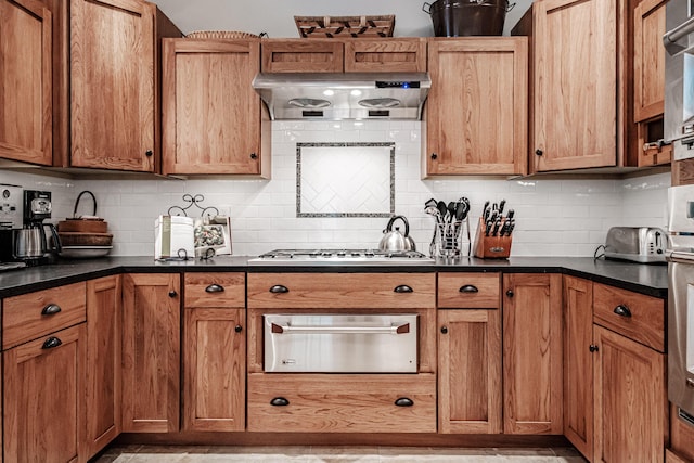 kitchen featuring range hood, stainless steel gas cooktop, and decorative backsplash