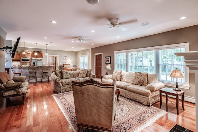 living room featuring ceiling fan and light wood-type flooring