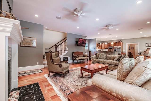 living room with ceiling fan and light hardwood / wood-style flooring