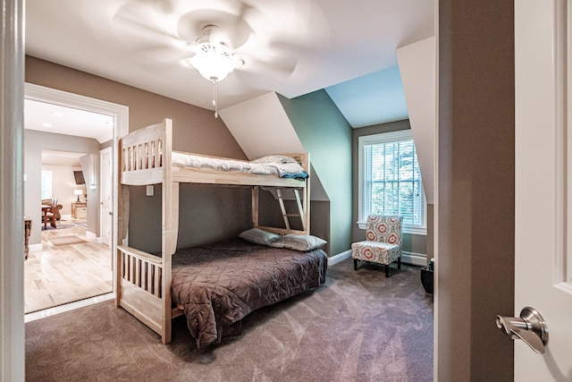 carpeted bedroom with lofted ceiling, ceiling fan, and baseboard heating