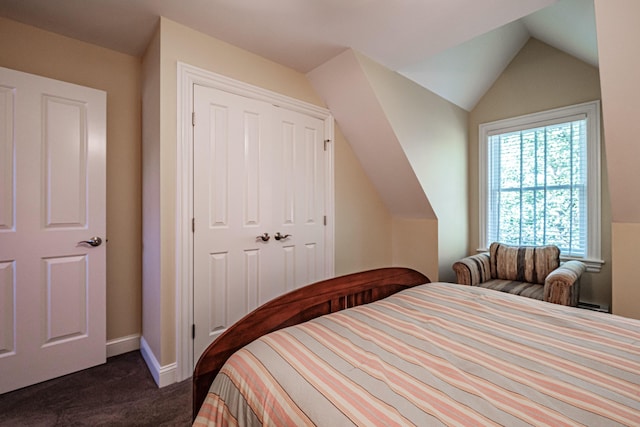 bedroom featuring vaulted ceiling, a closet, and dark colored carpet