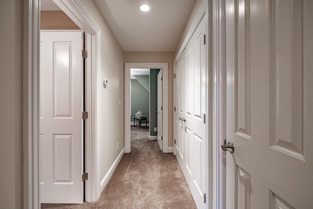 hall with light colored carpet