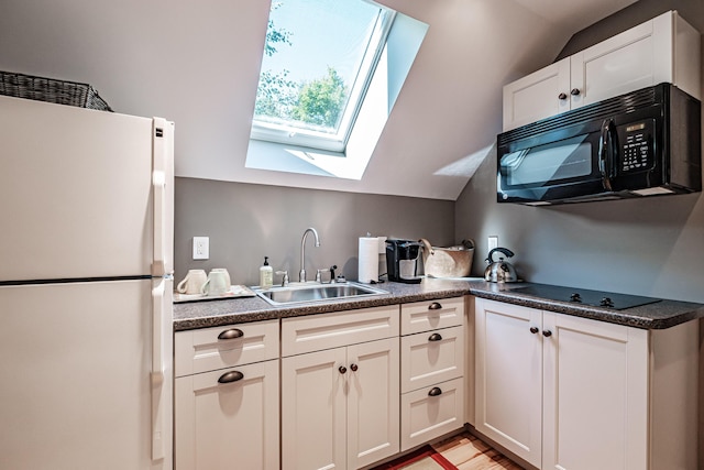 kitchen featuring white cabinetry, sink, lofted ceiling with skylight, and black appliances