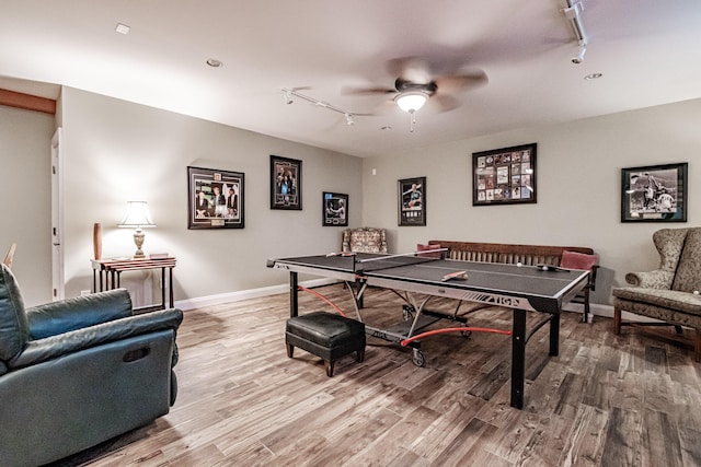 recreation room with hardwood / wood-style floors, rail lighting, and ceiling fan