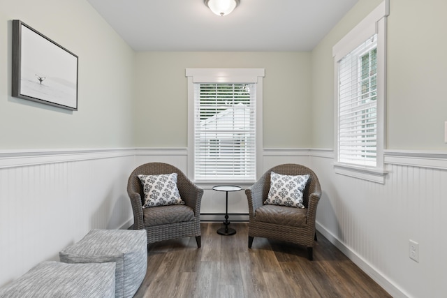 sitting room featuring a baseboard heating unit and dark wood-type flooring