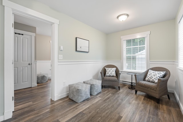 living area with dark hardwood / wood-style floors and baseboard heating