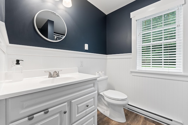 bathroom with vanity, wood-type flooring, baseboard heating, and toilet