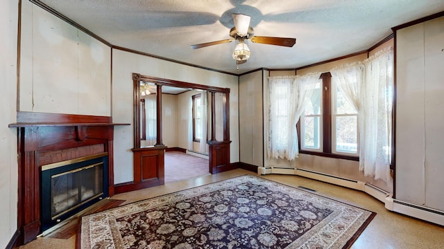 living room with ceiling fan, a textured ceiling, baseboard heating, and ornamental molding