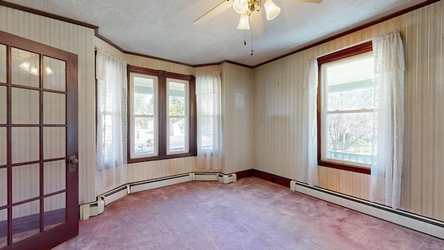 unfurnished room with carpet flooring, a baseboard heating unit, and plenty of natural light