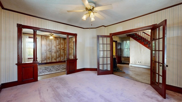 carpeted empty room featuring french doors, a textured ceiling, a baseboard heating unit, and ceiling fan