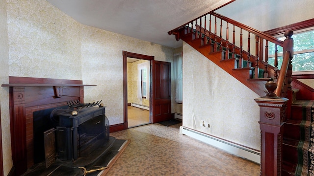 living room featuring carpet, a wood stove, and a baseboard radiator