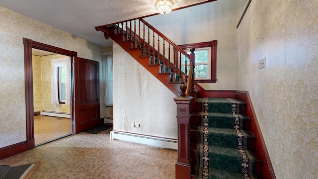 stairs featuring a baseboard heating unit, carpet floors, and a healthy amount of sunlight