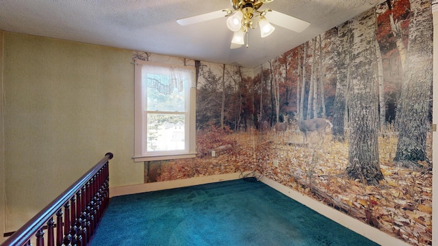 carpeted spare room with a textured ceiling and ceiling fan