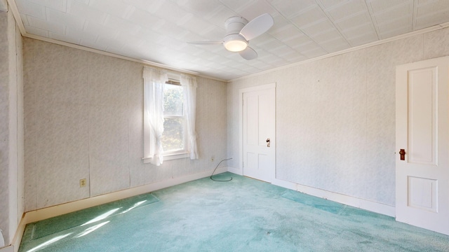 carpeted spare room with crown molding and ceiling fan