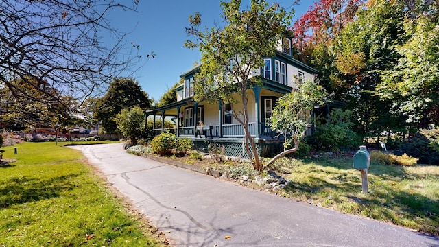 view of property exterior with a lawn and covered porch