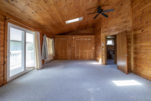 carpeted empty room with ceiling fan, wooden ceiling, a baseboard radiator, wooden walls, and vaulted ceiling