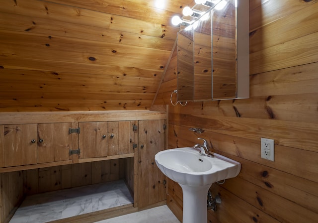 bathroom featuring wood walls and marble finish floor