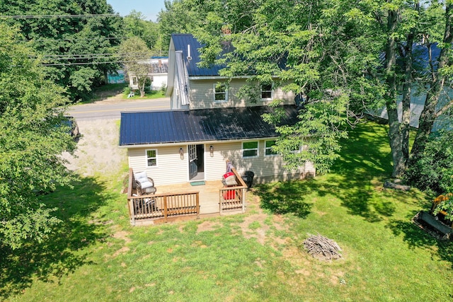 rear view of property featuring a wooden deck and a yard