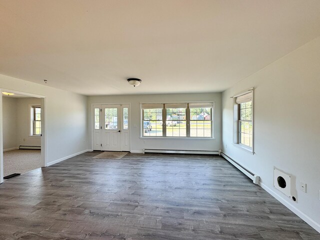 interior space featuring a baseboard heating unit, dark wood finished floors, baseboards, and baseboard heating