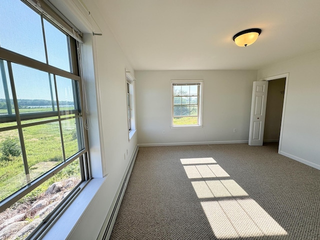 carpeted spare room featuring baseboards and baseboard heating