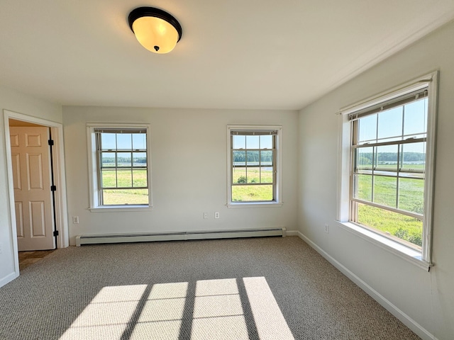 carpeted spare room with baseboard heating, a healthy amount of sunlight, and baseboards