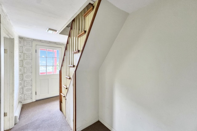 hall with baseboards, carpet flooring, stairs, and a baseboard radiator