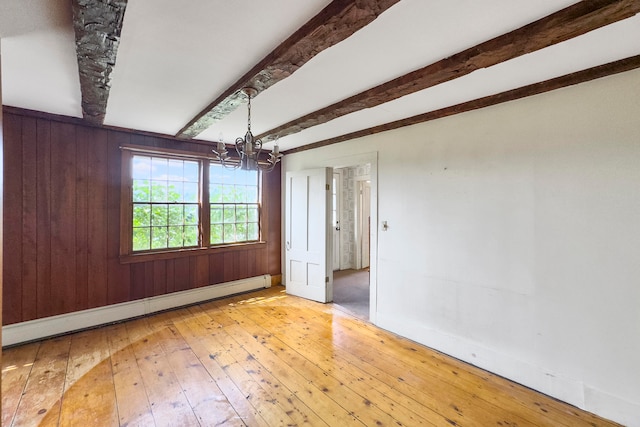 empty room with beam ceiling, an inviting chandelier, a baseboard heating unit, and light wood-type flooring